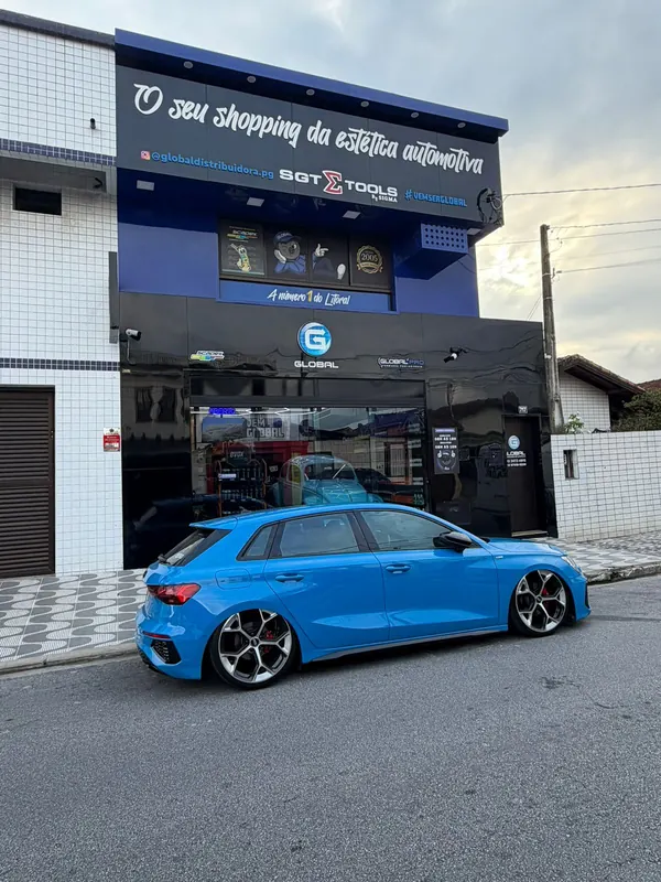 Fachada da Global Distribuidora em Praia Grande, com um carro azul estacionado em frente